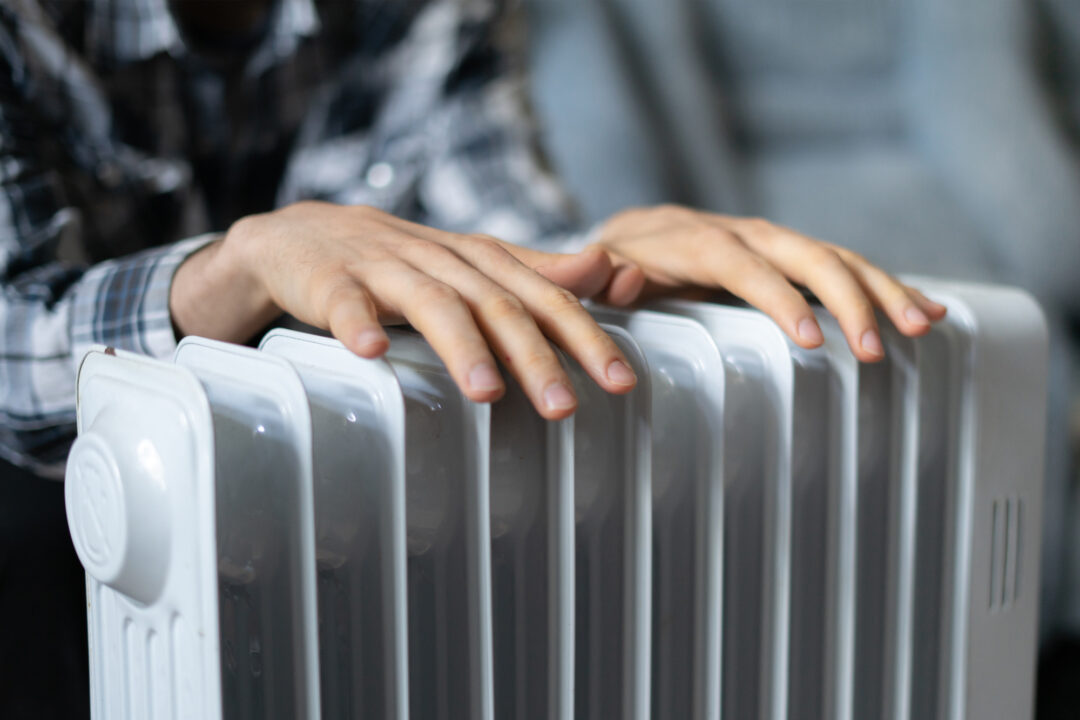 feeling cold, getting warm, hands touching heater close up