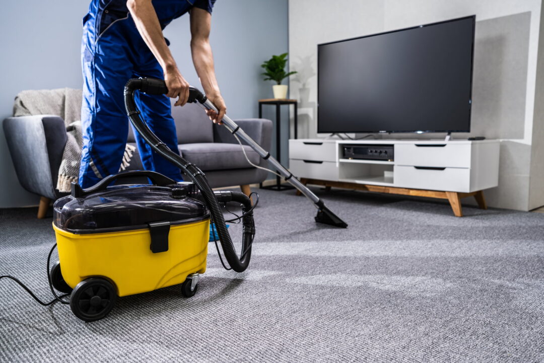 Person Cleaning Carpet With Vacuum Cleaner